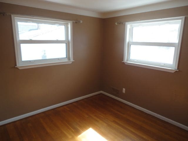 unfurnished room featuring plenty of natural light and baseboards