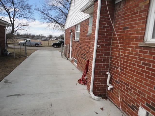 view of home's exterior with fence and brick siding