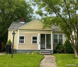 bungalow-style house featuring a front yard and a chimney