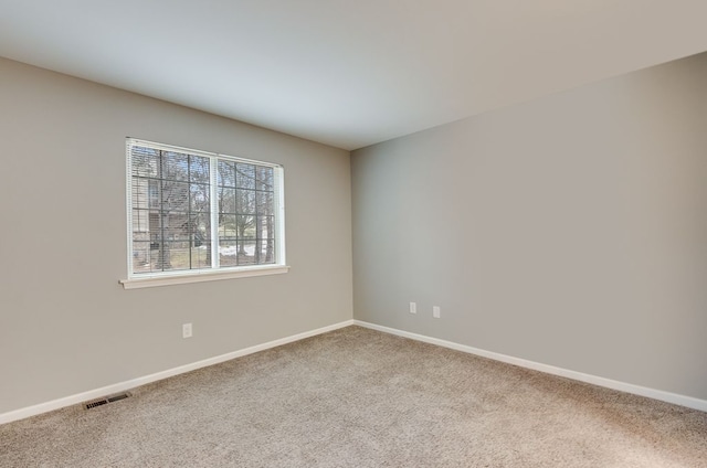 carpeted empty room featuring visible vents and baseboards