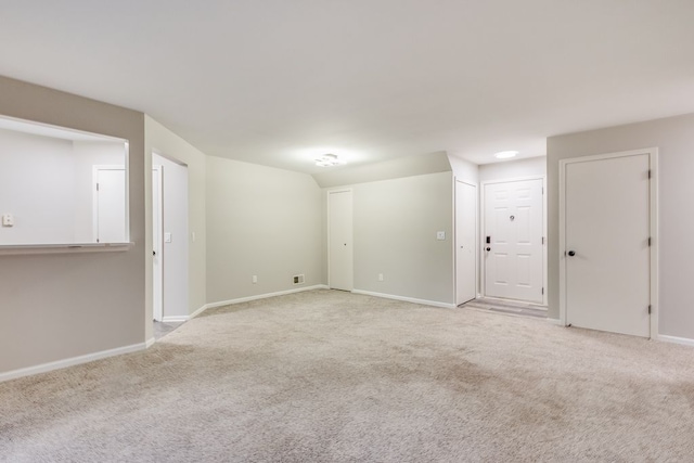 unfurnished room featuring light colored carpet and baseboards