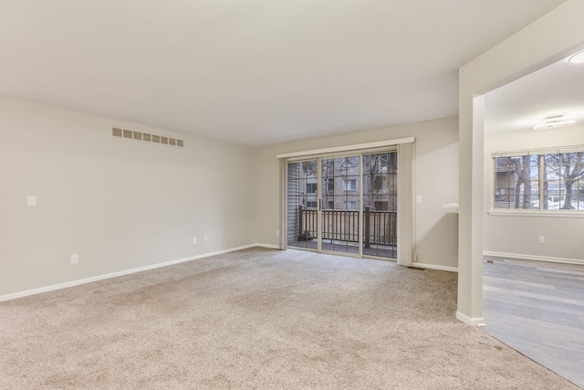 unfurnished room featuring carpet floors, baseboards, and visible vents