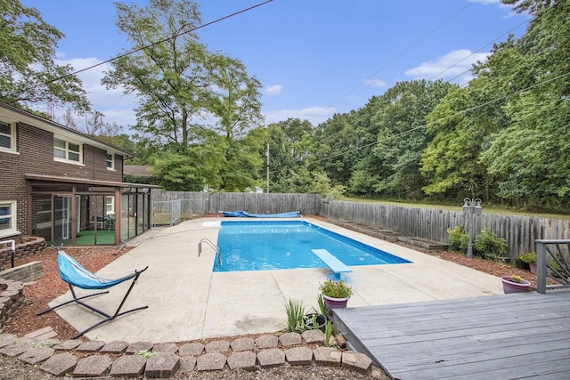 view of swimming pool with a patio area, a fenced backyard, a diving board, and a fenced in pool