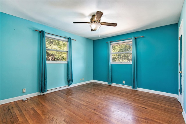 empty room with a ceiling fan, a healthy amount of sunlight, baseboards, and wood finished floors