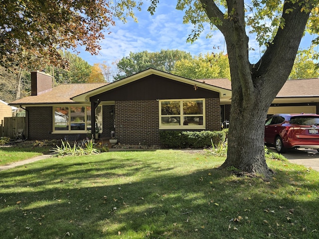 single story home with brick siding, a chimney, and a front lawn