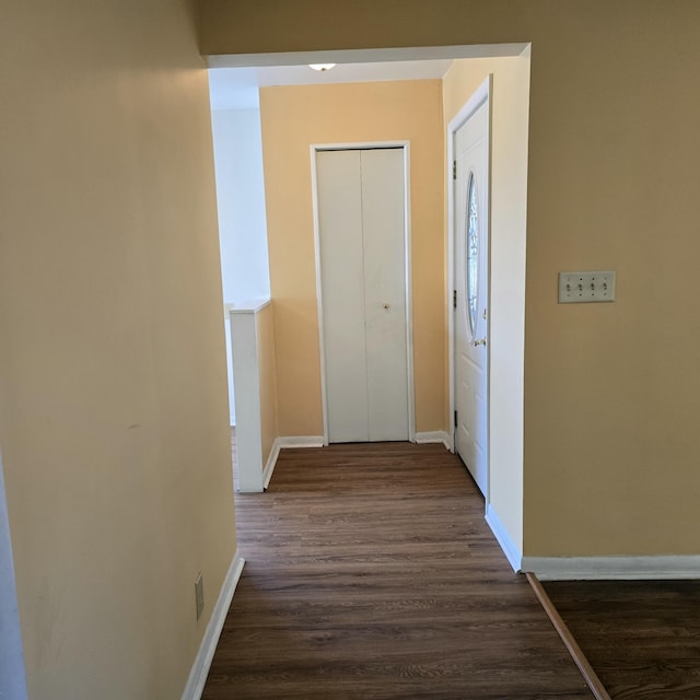 corridor featuring dark wood-style floors and baseboards