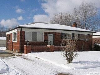 view of front facade with brick siding and a chimney