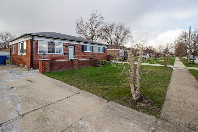 view of front facade with a front lawn, concrete driveway, and brick siding