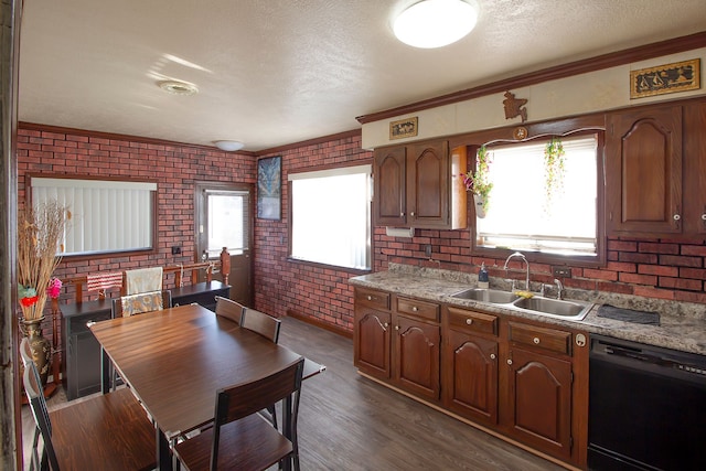 kitchen featuring a textured ceiling, a sink, light countertops, brick wall, and dishwasher