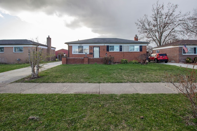bungalow-style home with driveway, a chimney, a front yard, and brick siding