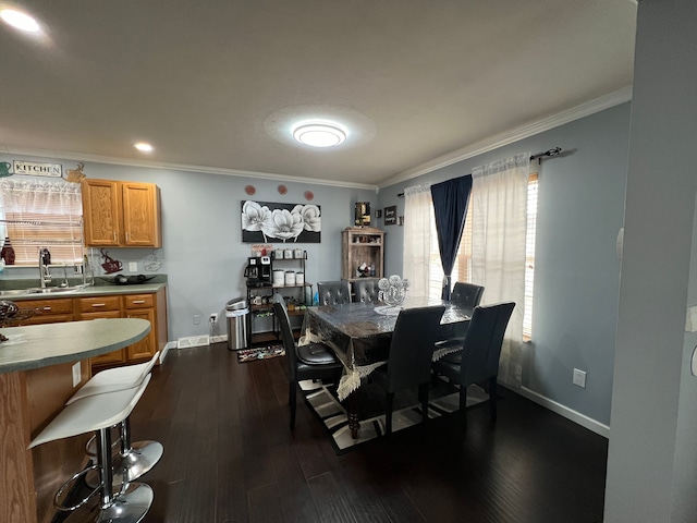 dining area featuring dark wood-style floors, crown molding, and baseboards