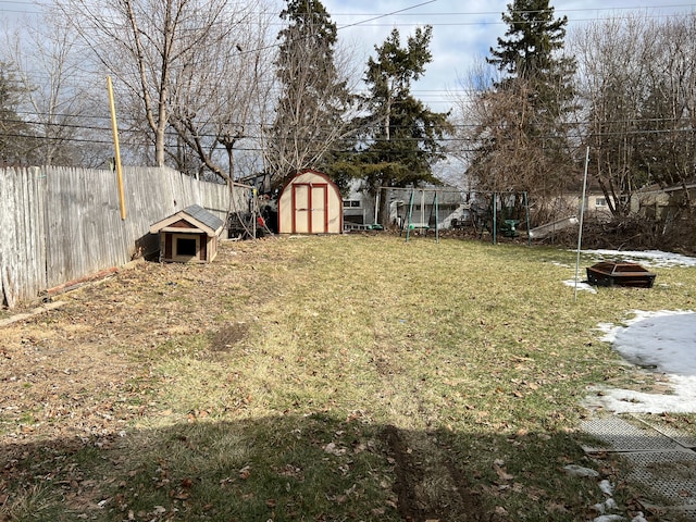 view of yard featuring an outbuilding, a shed, and a fenced backyard