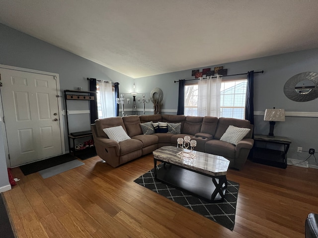 living area with vaulted ceiling and wood finished floors