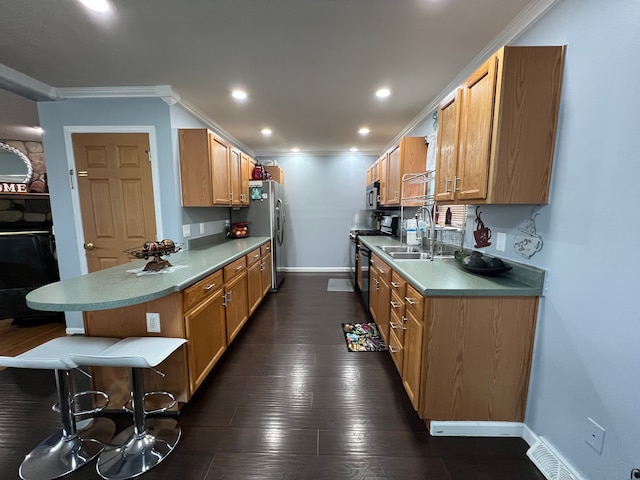 kitchen featuring stainless steel appliances, dark wood-style flooring, a sink, baseboards, and ornamental molding