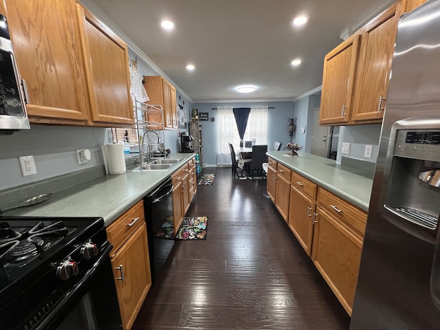 kitchen with a sink, light countertops, black appliances, dark wood finished floors, and crown molding