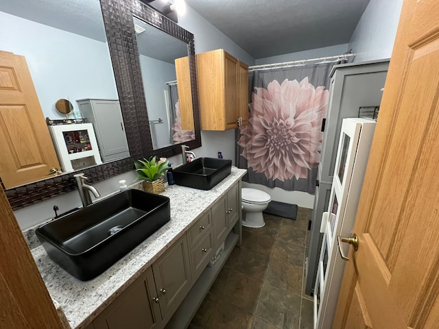 full bath with toilet, double vanity, a sink, and a shower with shower curtain