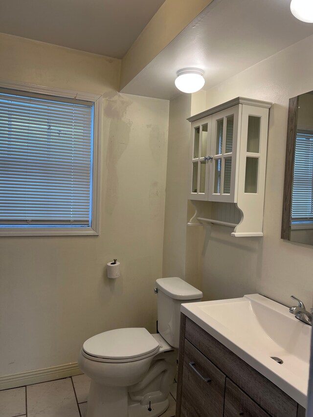 bathroom with toilet, marble finish floor, baseboards, and vanity