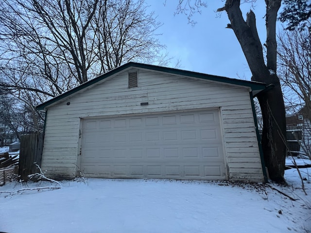 snow covered garage with a garage