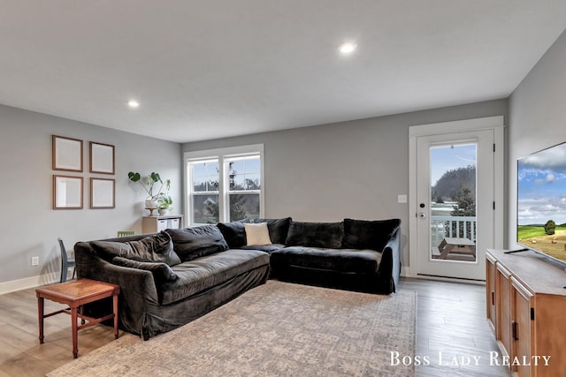 living room with light wood-type flooring, a wealth of natural light, and recessed lighting