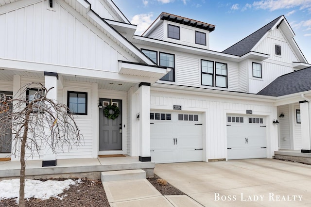 exterior space with board and batten siding, driveway, and a garage