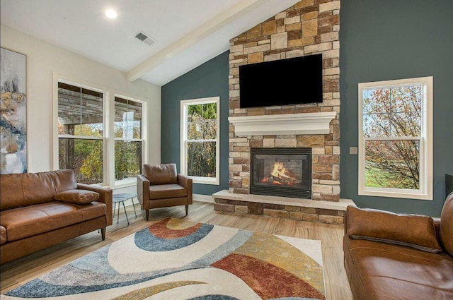 sitting room featuring lofted ceiling with beams, a fireplace, visible vents, and wood finished floors