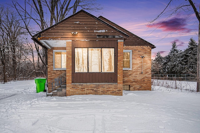 exterior space featuring brick siding and fence