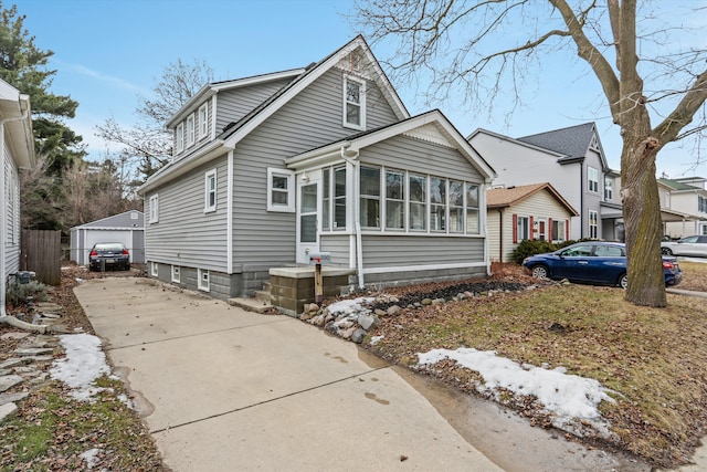 bungalow-style house featuring an outbuilding and a sunroom