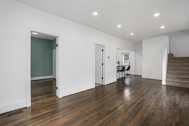 unfurnished living room with baseboards, visible vents, stairway, wood finished floors, and recessed lighting