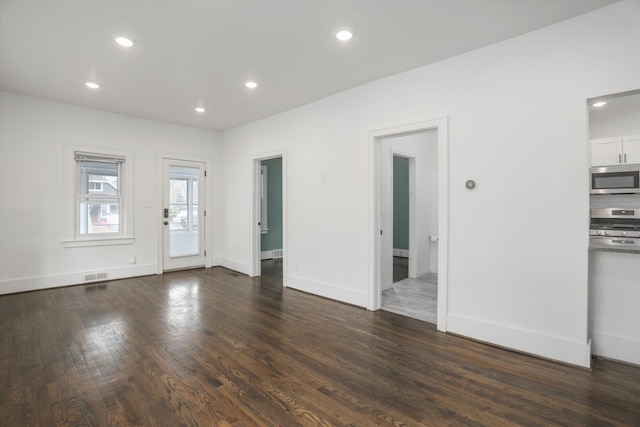 unfurnished living room with recessed lighting, dark wood-style flooring, visible vents, and baseboards