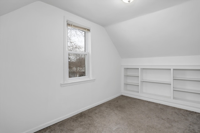 bonus room with carpet floors, baseboards, built in features, and lofted ceiling