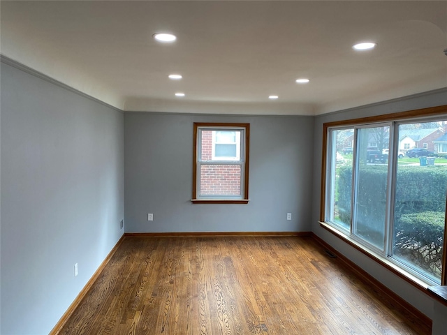 empty room featuring recessed lighting, wood finished floors, and baseboards