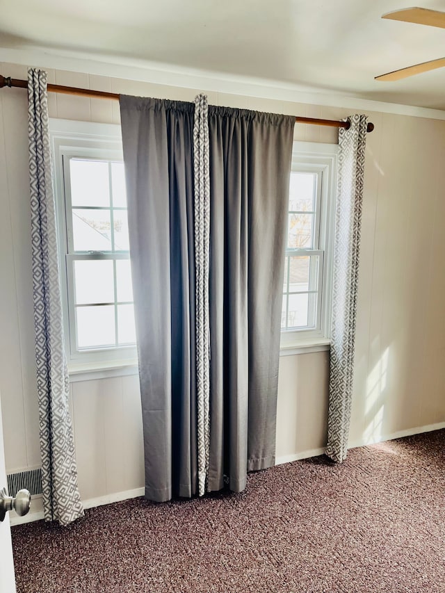 unfurnished room with ceiling fan, carpet flooring, and visible vents