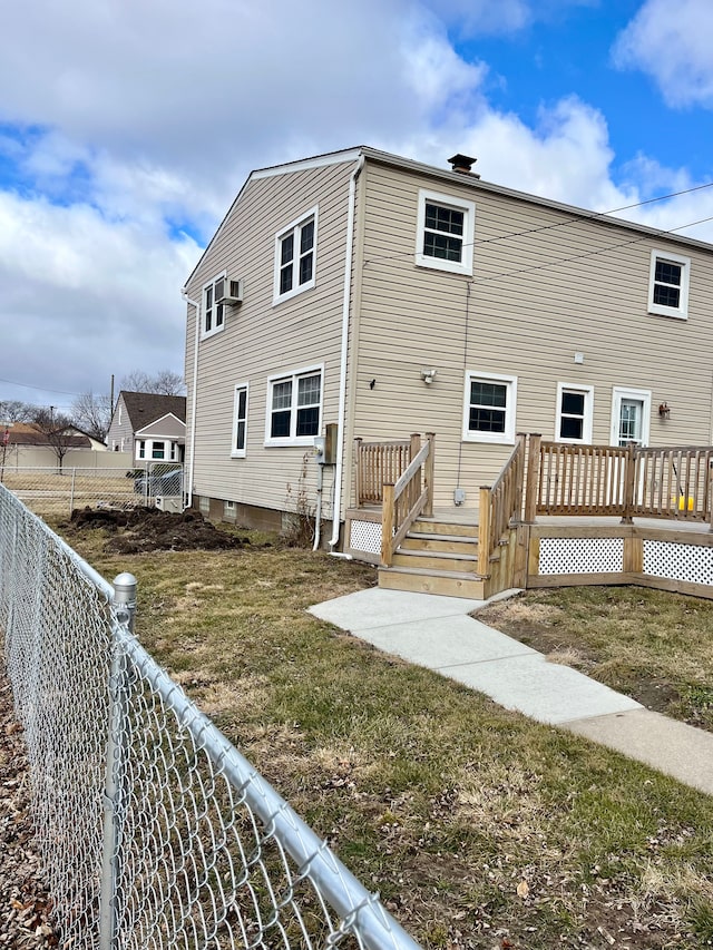 back of property with a fenced backyard, a yard, and a wooden deck