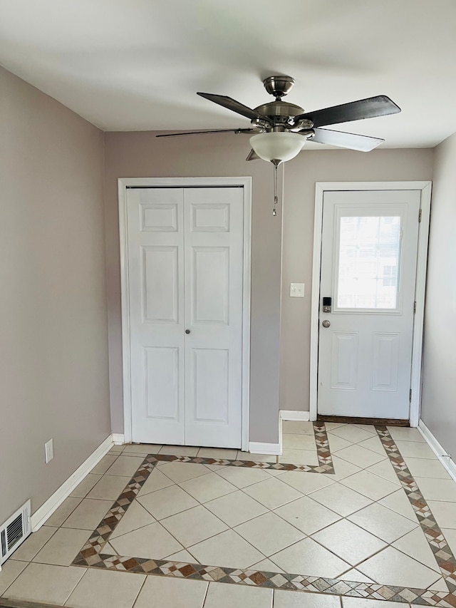 entrance foyer with light tile patterned floors, visible vents, baseboards, and a ceiling fan