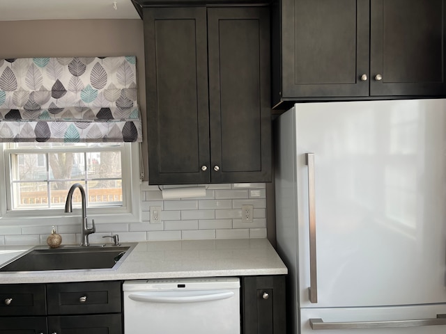 kitchen with refrigerator, a sink, light countertops, decorative backsplash, and dishwasher