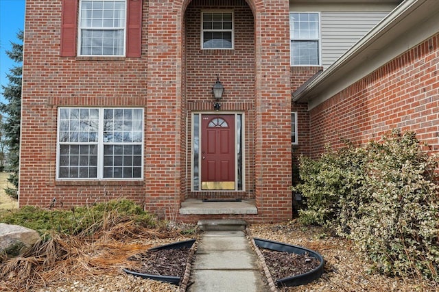 entrance to property featuring brick siding