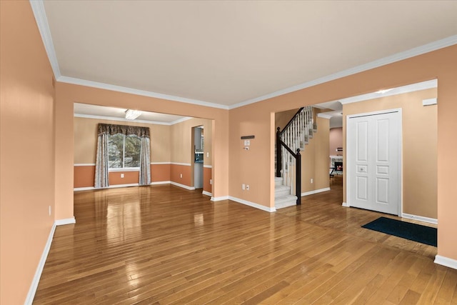 unfurnished living room featuring crown molding, stairway, wood-type flooring, and baseboards