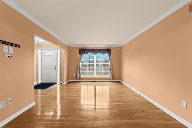 entryway with crown molding, baseboards, and wood finished floors