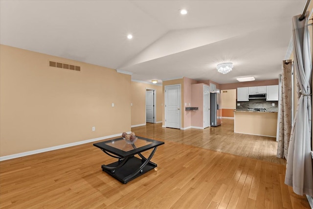 workout area with recessed lighting, visible vents, baseboards, vaulted ceiling, and light wood-type flooring