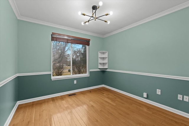 empty room with visible vents, ornamental molding, a chandelier, baseboards, and hardwood / wood-style flooring