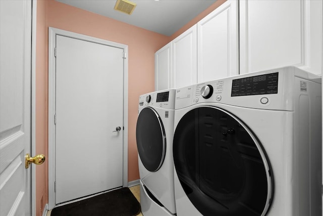 laundry room with visible vents, cabinet space, and washing machine and clothes dryer