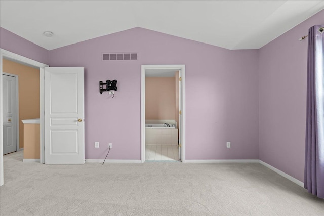 unfurnished bedroom with baseboards, visible vents, vaulted ceiling, and carpet flooring