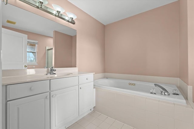 bathroom with tile patterned floors, visible vents, a bath, and vanity