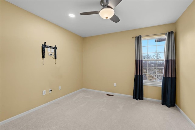 empty room with a ceiling fan, carpet flooring, visible vents, and baseboards