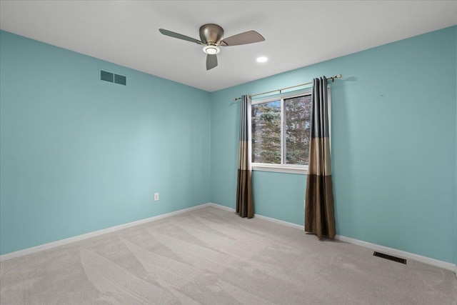 empty room with light carpet, baseboards, visible vents, and a ceiling fan