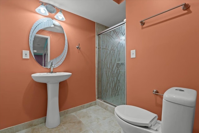 bathroom with a stall shower, baseboards, toilet, and tile patterned floors