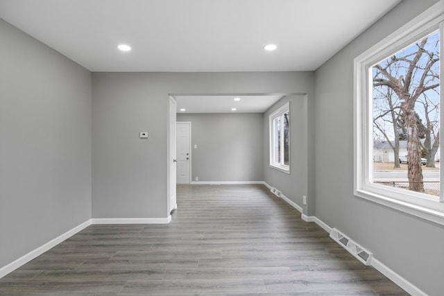 empty room featuring recessed lighting, wood finished floors, and baseboards