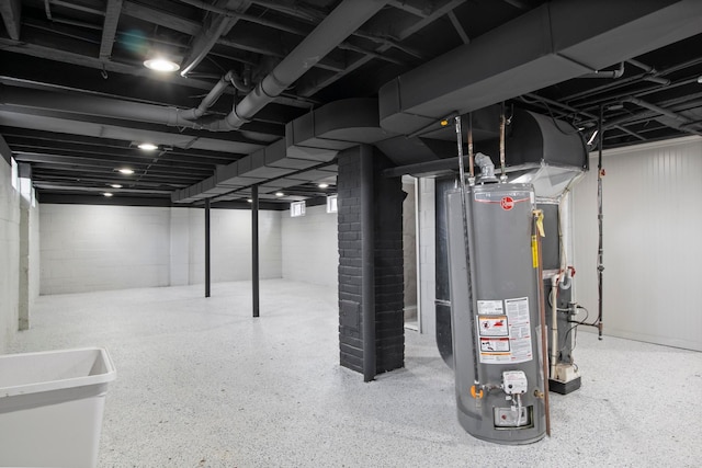 finished basement featuring concrete block wall and gas water heater