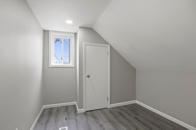 bonus room with visible vents, vaulted ceiling, baseboards, and wood finished floors