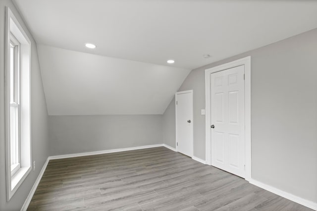 bonus room with baseboards, vaulted ceiling, wood finished floors, and recessed lighting